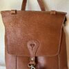 MOCHILA DE CUERO CON BROCHE EN EL FRENTE Y CIERRE ARRIBA - CIERRRE ATRAS